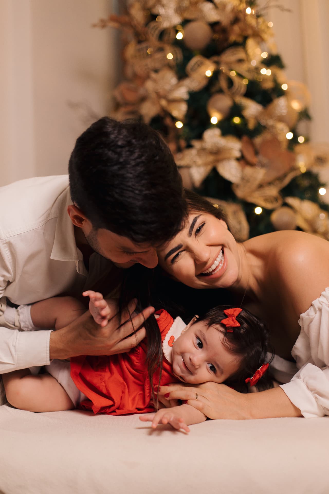 Pai e mãe abraçando a filha deitada