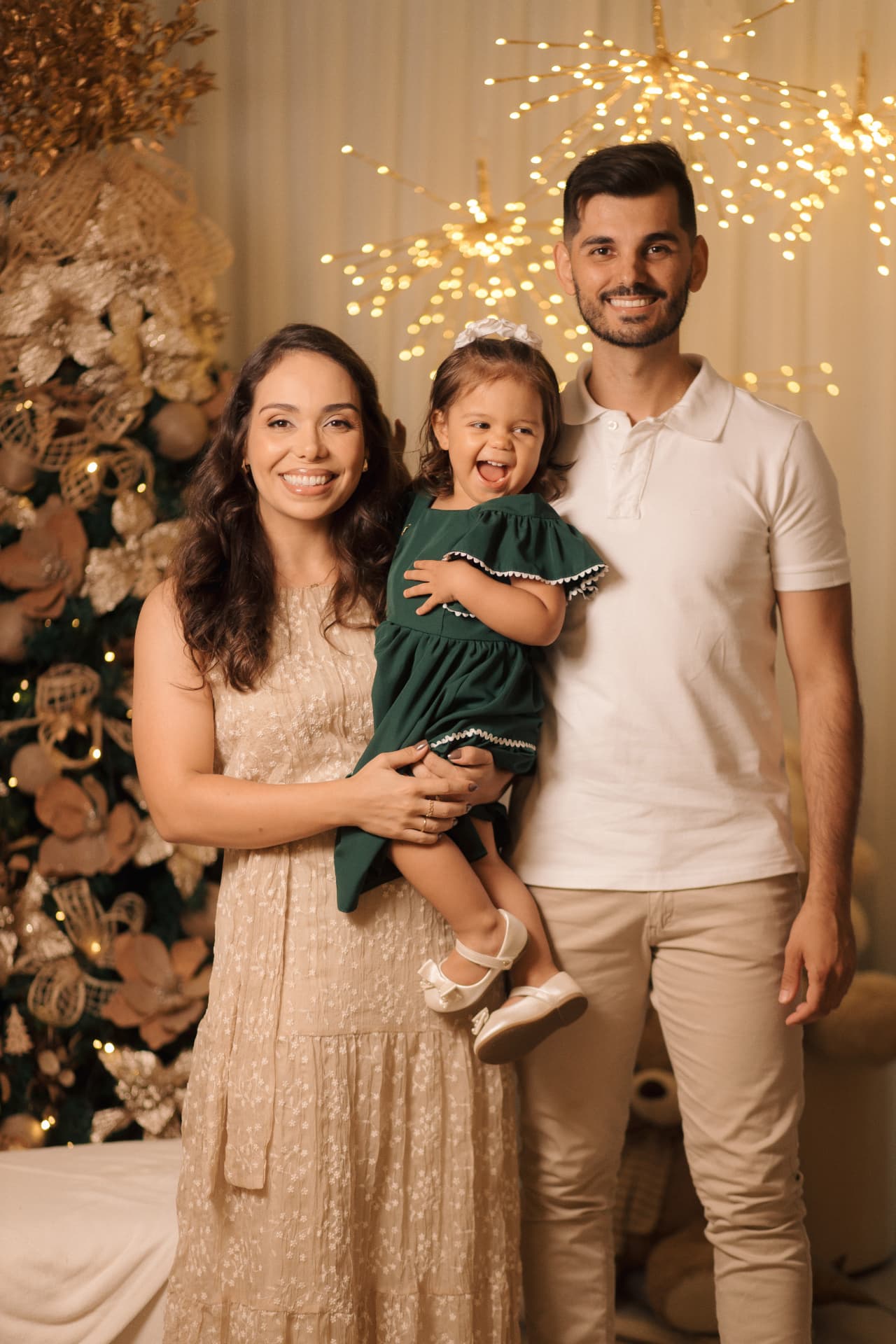 Pai e mãe com a filha de vestido verde